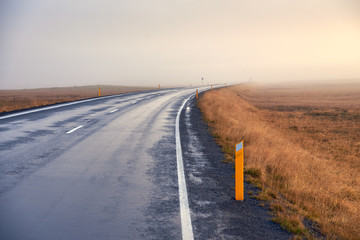 Asphalt road in fog in Iceland, Autumn