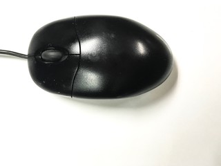 Old black mouse on white desk background.