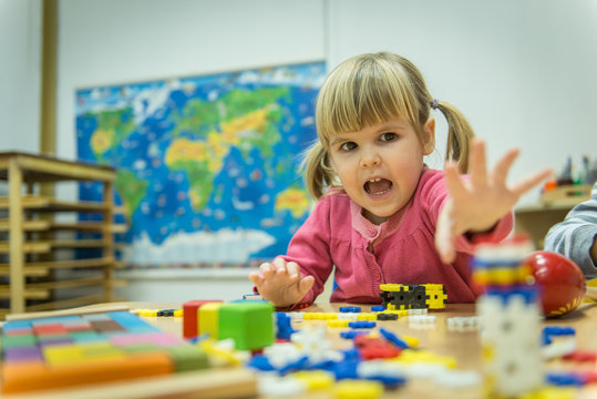 Portrait of caucasian little girl playing with wooden toys