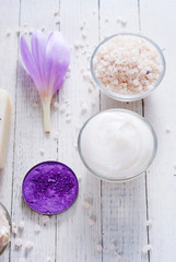 beauty product samples and autumn crocus herbal flower on white wooden table