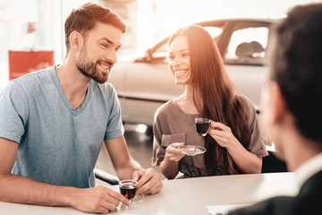 Young Family Are Choosing A New Car In Showroom.