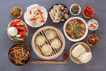 Dishes of Chinese cuisine in assortment. Steam dumplings, noodles, salads, vegetables, mushrooms, seafood. Top view.