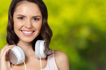 Portrait of brunette beauty listening to music in white headphones