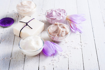 Obraz na płótnie Canvas cosmetic cream variations, soap and bath salt with autumn crocus herbal flower on white wooden table