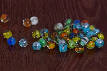glass Marbles on dark wooden floor