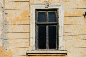 Old window on abandoned residentual house close up shot on a sunny day.
