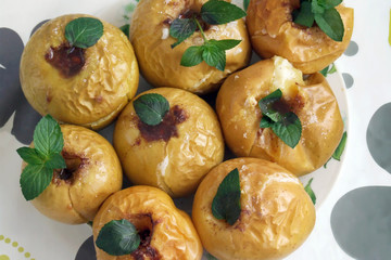 baked apples with honey, cinnamon, decorated with mint leaves, top view. Homemade biffin, healthy food, vegetarianism, low-calorie dessert.
