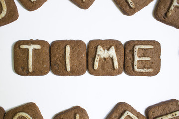 White letters on a chocolate cookie. The inscription 