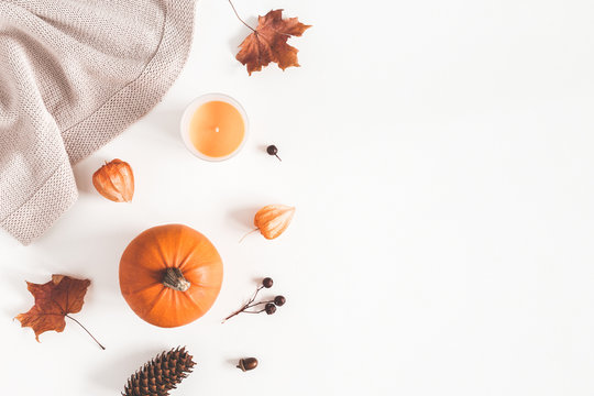 Autumn composition. Pumpkins, plaid, candles, dried leaves on white background. Autumn, fall, halloween concept. Flat lay, top view, copy space