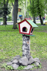 a self-made birdhouse in the park, a birdhouse in the form of a house, concept of nature conservation 