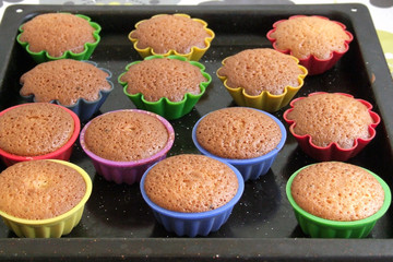 homemade cupcakes in multi-colored silicone molds on a baking tray. delicious pastry cooked at home, dessert for tea.