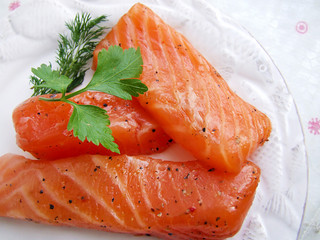 pieces of red marinated salmon on a white plate 