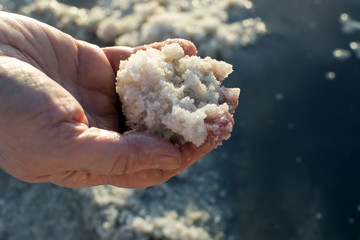 Fototapeta na wymiar salt lake, collection of salt, hand with salt in the foreground, background salt lake