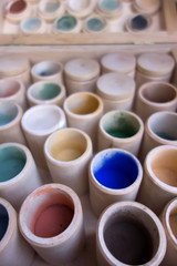 Jars with colorful paints background
