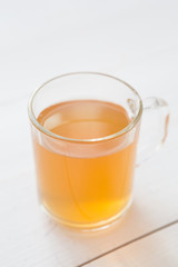 Glass mug of yellow herbal tea