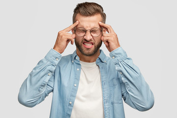 Let me think. Desperate hipster man holds fingers on temples, scowls face, clenches teeth, has...