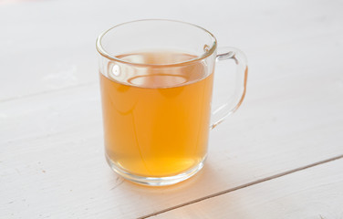 Glass mug of yellow herbal tea