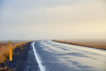 Asphalt road in fog in Iceland, Autumn