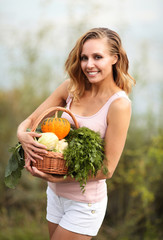 Kobieta trzymająca kosz z warzywami - obrazy, fototapety, plakaty