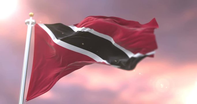 Trinidad and Tobago flag waving at wind in slow at sunset, loop