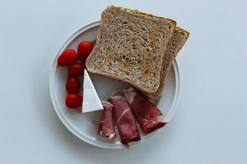 Brotzeitteller mit Schinken, Weichkäse, Toast und Tomaten