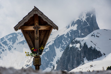 Capitello con crocifisso d'alta montagna, sullo sfondo montagna innevata