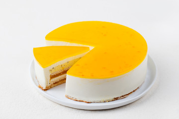 Passion fruit cake, mousse dessert on a white plate. Copy space.