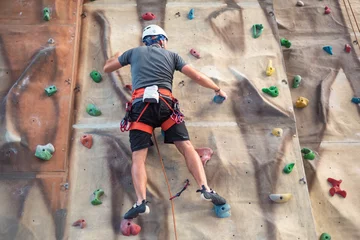 Foto op Plexiglas Young man practicing rock climbing on artificial wall indoors. © herraez