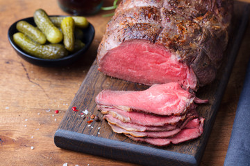 Roast beef on cutting board. Wooden background. © annapustynnikova