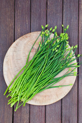 Chives flower, Garlic chives or Chinese Chive on a cutting board. Wooden background. Top view.