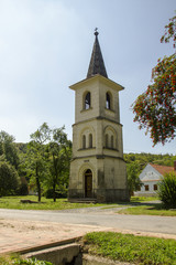 Fototapeta na wymiar Historic chapel with belfry. Old Bell tower in small town in Hungary. Hungarian village.
