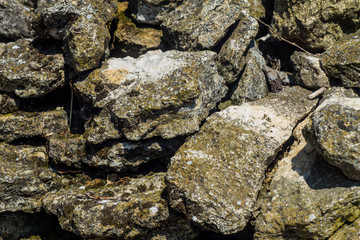 Stones background, gray large stones, boulders in the masonry, part of stone fence, close-up of stone border