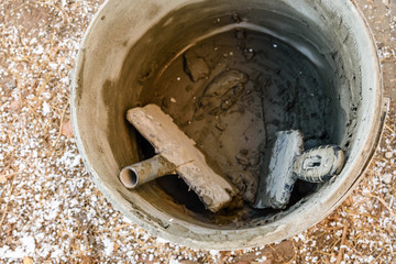 Two spatulas in bucket with the mortar