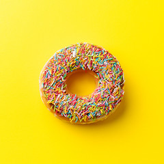 Donut on yellow background. Top view. Copy space.