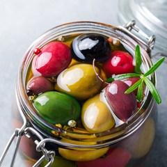 Olives assortment in glass jar with oil. Close up.