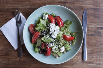 Vegetable salad with tomatoes, baked bell pepper, cheese and pieces of turkey meat