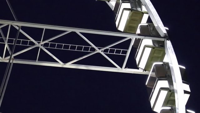 Close up lighted Budapest Eye wheel cabins at night time.