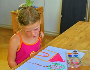 Cute little girl painting picture of house. Cute girl painting with watercolors. Mortage concept. Selective focus, small DOF
