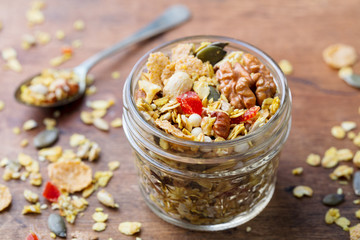 Granola, muesli in glass jar. Healthy breakfast. Organic oats with berries and nuts. Close up.