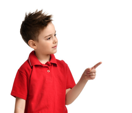 Young Boy Kid In Red Polo T-shirt Pointing One Finger At The Corner Isolated On White 