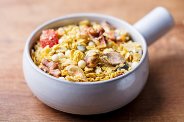 Granola, muesli in ceramic bowl. Healthy breakfast. Organic oats with apples, berries and nuts.