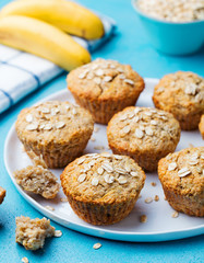 Healthy vegan oat muffins, apple and banana cakes on a white plate. Blue stone background.