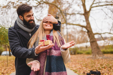 Man giving surprise gift to woman in the park 