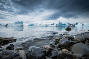 Eisberge schwimmend vor Steinen Island