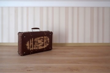 Old suitcase on the floor in an empty room