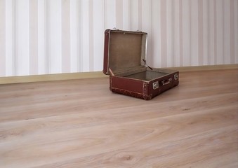 Old suitcase on the floor in an empty room