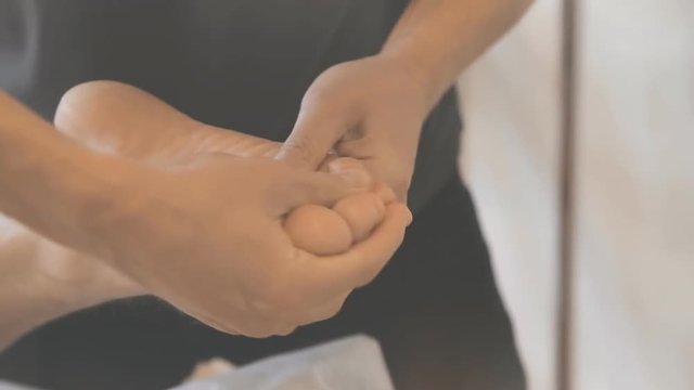 Massagist making foot massage for man