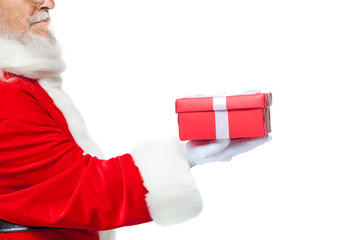 Christmas. Smiling Santa Claus in white gloves is holding a gift red box with a bow. Pointing at the gift. Isolated on white background. Close up