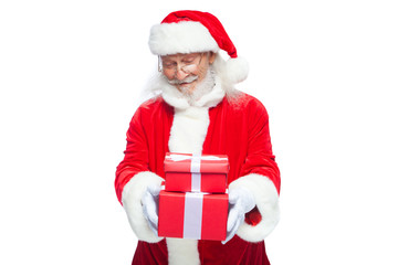 Christmas. Smiling Santa Claus in white gloves is holding two gift red boxes with a bow, one on the other. Isolated on white background.