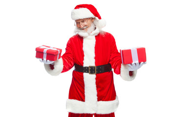 Christmas. Smiling Santa Claus in white gloves holds two boxes with gifts. The concept of choosing a gift, generous gifts. Isolated on white background.